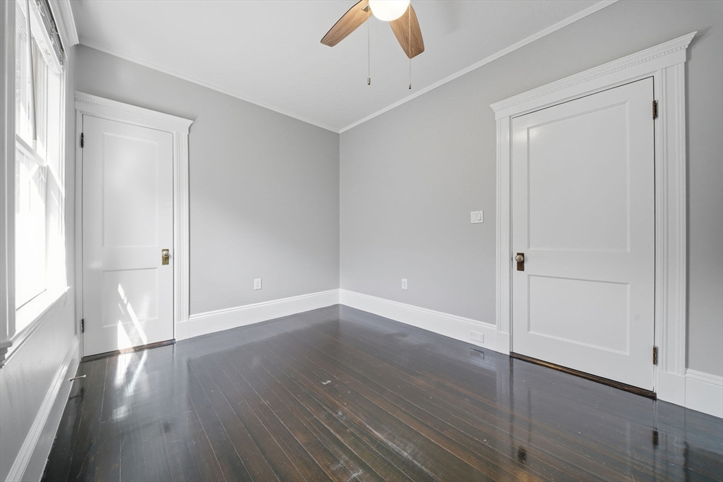 22 Trescott Street, Unit 3 Boston, MA 02125 - Photo 11 of 22 an empty room with wooden floor cabinet and windows