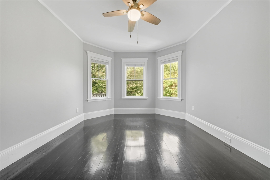 22 Trescott Street, Unit 3 Boston, MA 02125 - Photo 15 of 22 an empty room with wooden floor chandelier fan and windows
