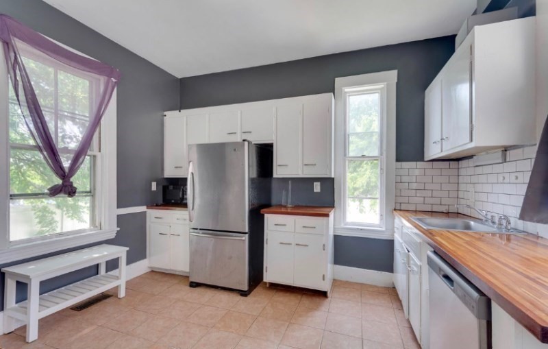 12 Fiske Street, Unit 1 Waltham, MA 02451 - Photo 2 of 18 a kitchen with stainless steel appliances a refrigerator sink and cabinets