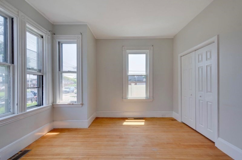 12 Fiske Street, Unit 1 Waltham, MA 02451 - Photo 4 of 18 a view of an empty room with wooden floor and a window