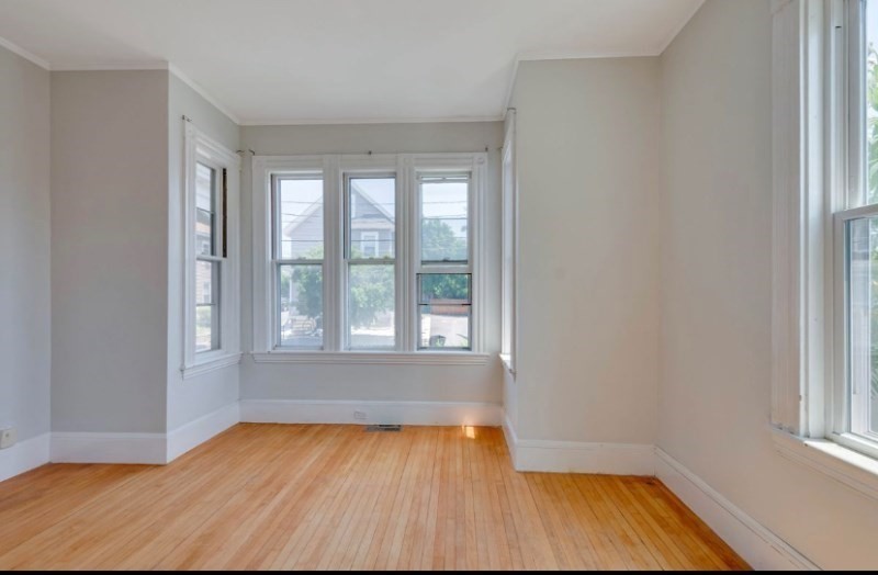 12 Fiske Street, Unit 1 Waltham, MA 02451 - Photo 5 of 18 an empty room with wooden floor and windows