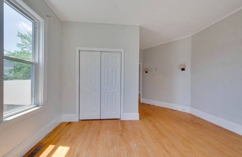 12 Fiske Street, Unit 1 Waltham, MA 02451 - Photo 6 of 18 a view of an empty room with wooden floor and a window