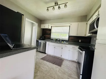 a living room with a couch and a dresser next to a window