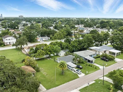 an aerial view of residential houses with outdoor space and trees