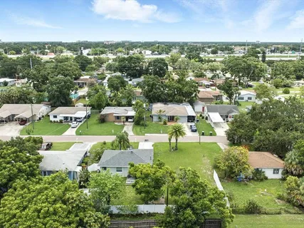 an aerial view of residential houses with outdoor space and trees