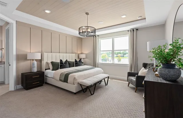 a spacious bedroom with a bed and a chandelier