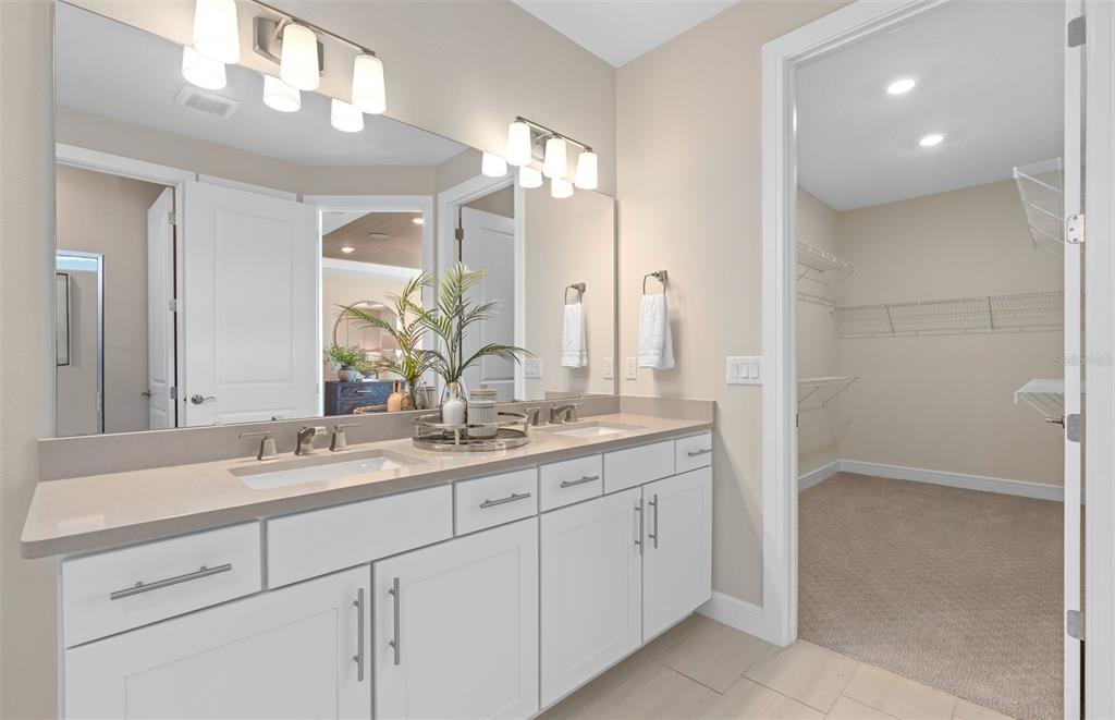 6249 Dew Drop Loop St. Cloud, FL 34771 - Photo 18 of 26 a bathroom with a double vanity sink and a mirror