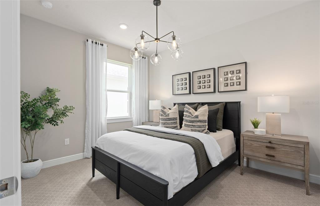 6249 Dew Drop Loop St. Cloud, FL 34771 - Photo 21 of 26 a bedroom with a bed and a potted plant