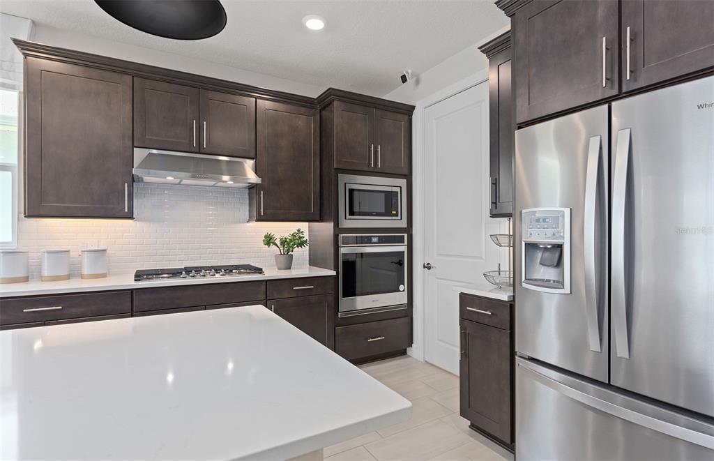 6249 Dew Drop Loop St. Cloud, FL 34771 - Photo 8 of 26 a kitchen with stainless steel appliances a refrigerator sink and stove