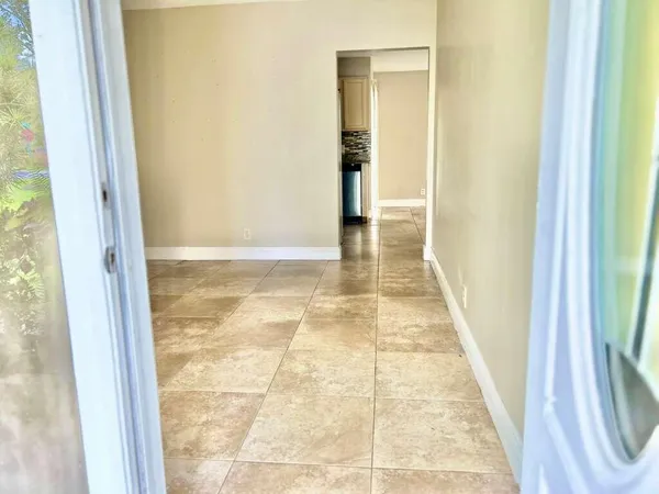 a view of hallway with shower and a mirror