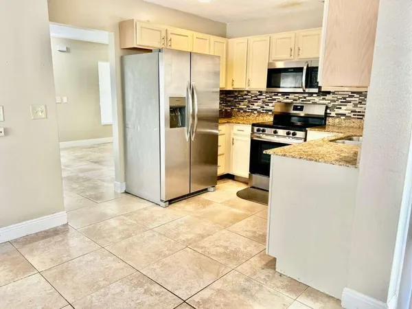 a kitchen with stainless steel appliances a refrigerator sink and stove