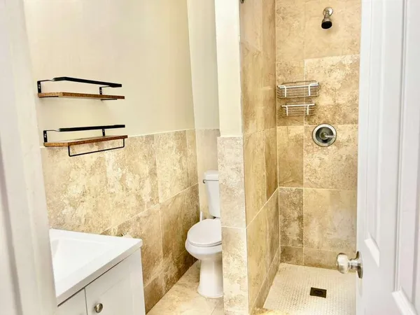 a bathroom with a sink a toilet and shower