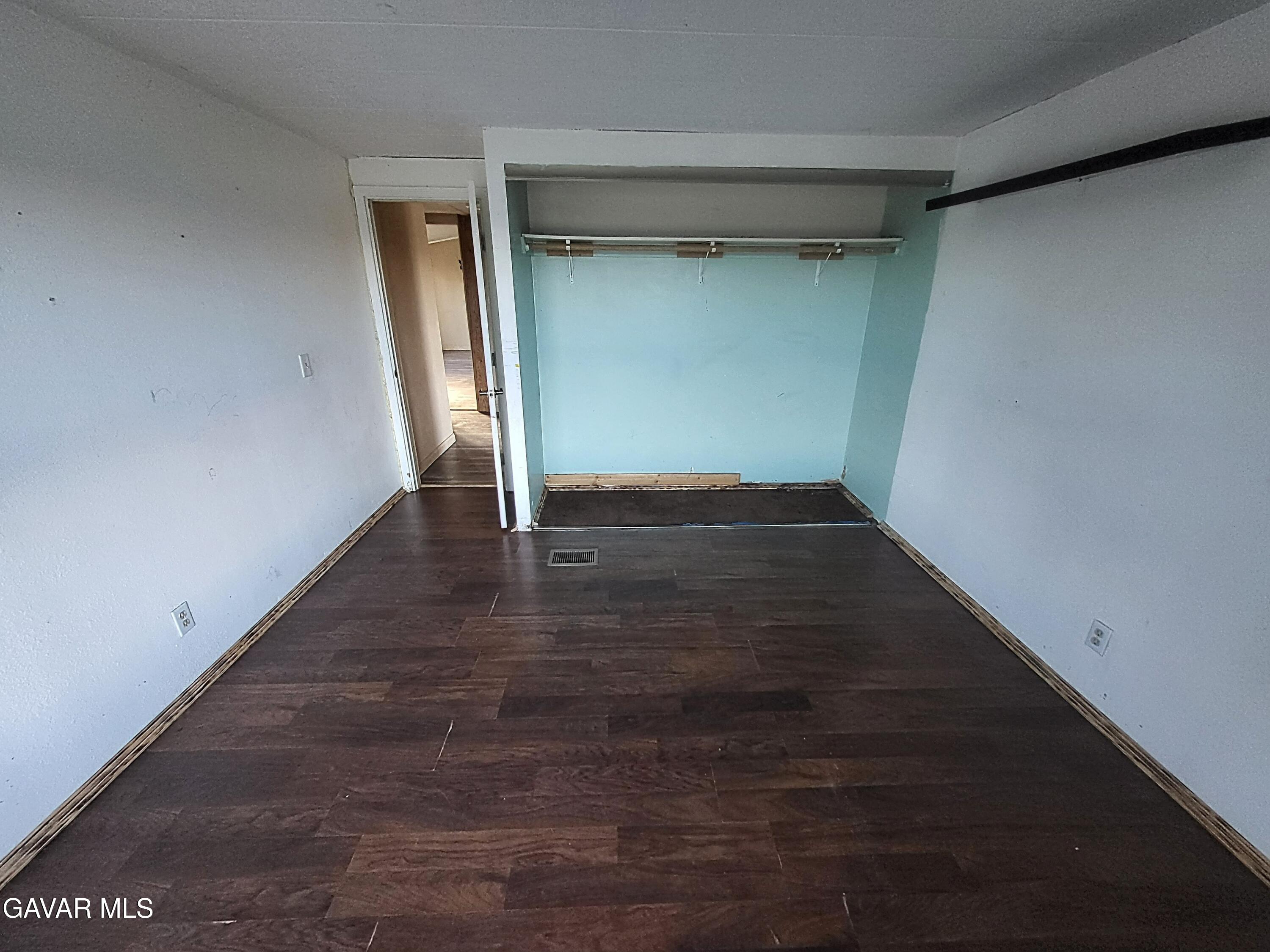 8667 70th Street West Mojave, CA 93501 - Photo 21 of 32 an empty room with wooden floor and closet