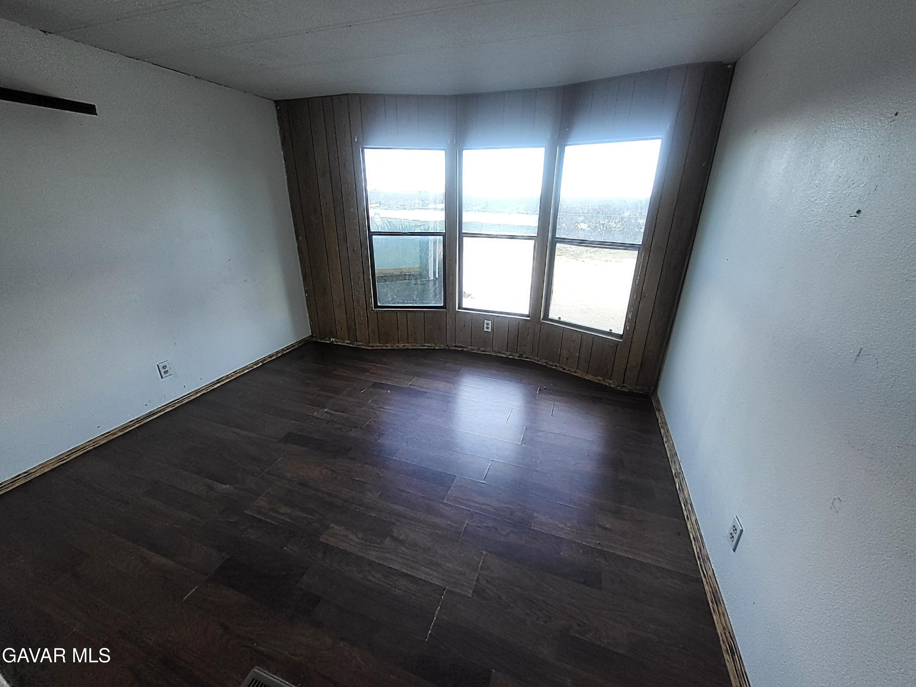 8667 70th Street West Mojave, CA 93501 - Photo 21 of 32 an empty room with wooden floor and windows