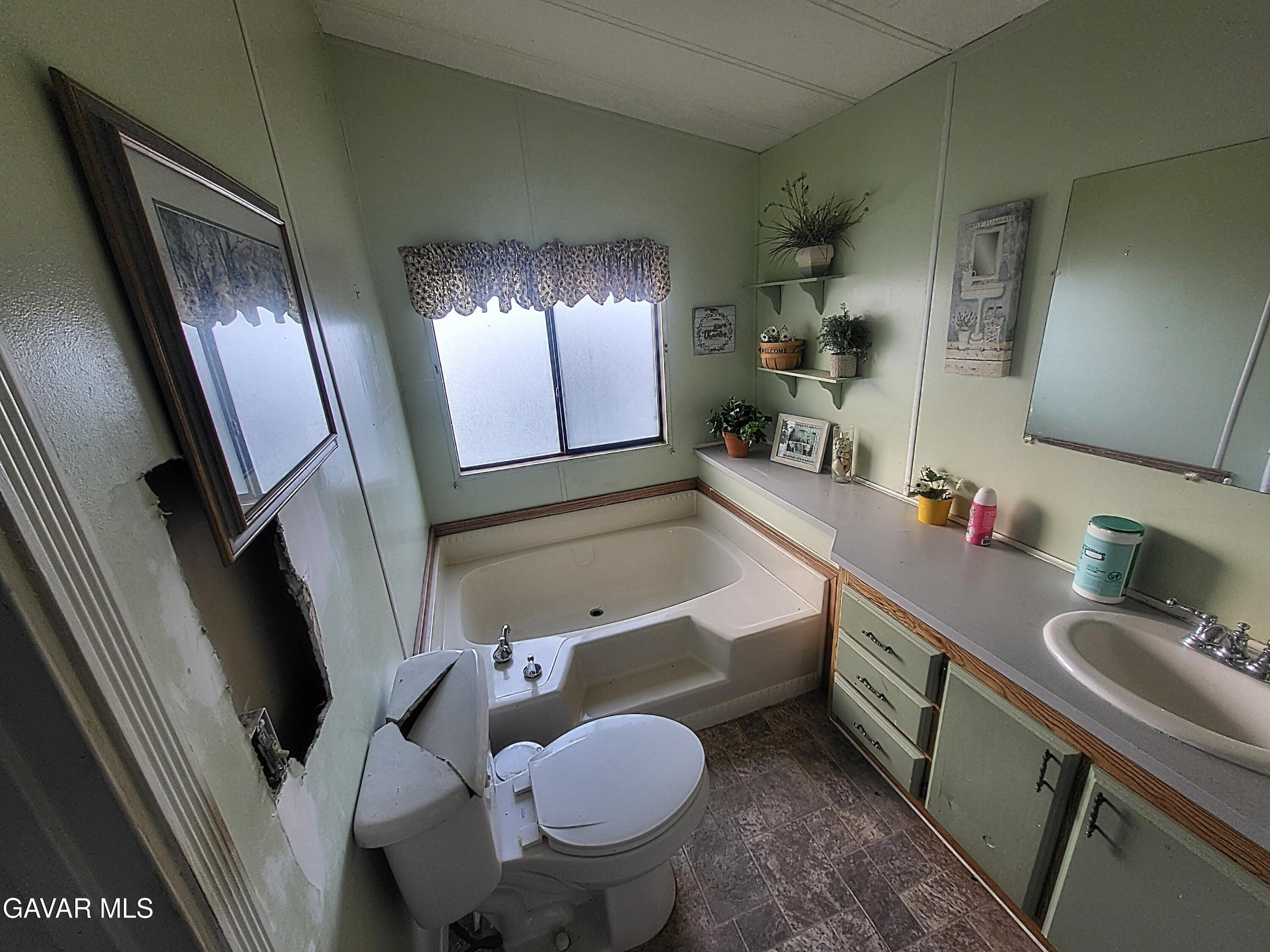 8667 70th Street West Mojave, CA 93501 - Photo 5 of 32 a bathroom with a granite countertop sink mirror vanity and toilet