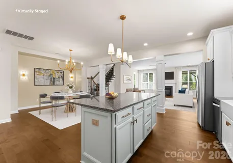 a dining room with wooden floor a chandelier a glass table and chairs