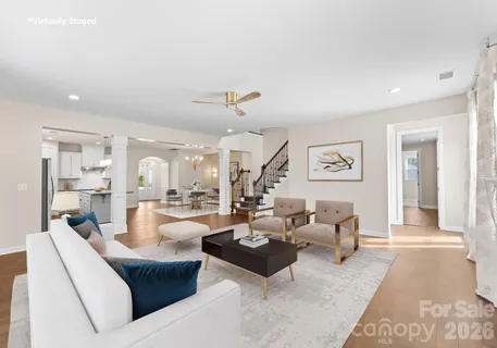 a living room with fireplace furniture and a view of kitchen