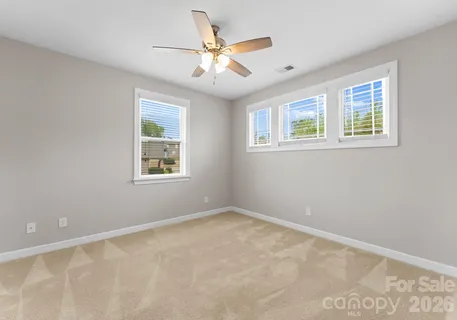 an empty room with a window and a fan