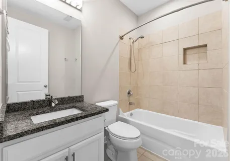 a view of an empty room with a window and a kitchen