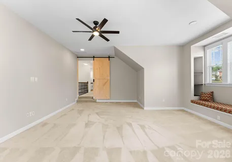 an empty room with wooden floor and window