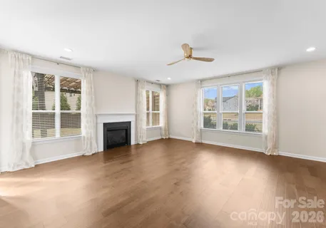a view of a livingroom with wooden floor and stairs