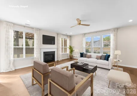 a living room with furniture a fireplace and a large window