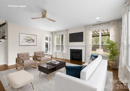 a living room with furniture fireplace and a large window