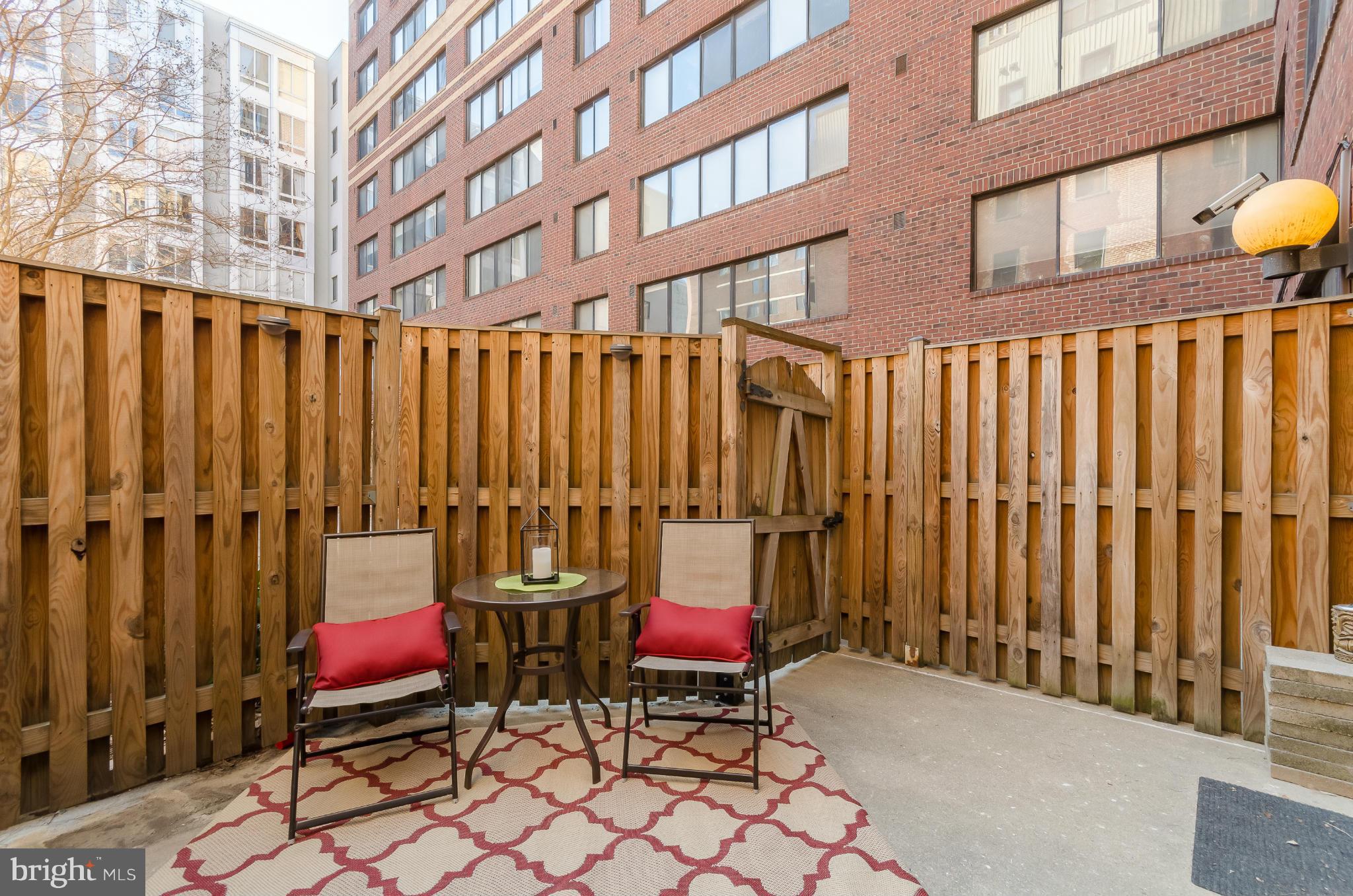 1245 13th Street Northwest, Unit 101 Washington, DC 20005 - Photo 16 of 25 a backyard of a building with glass top table and chairs