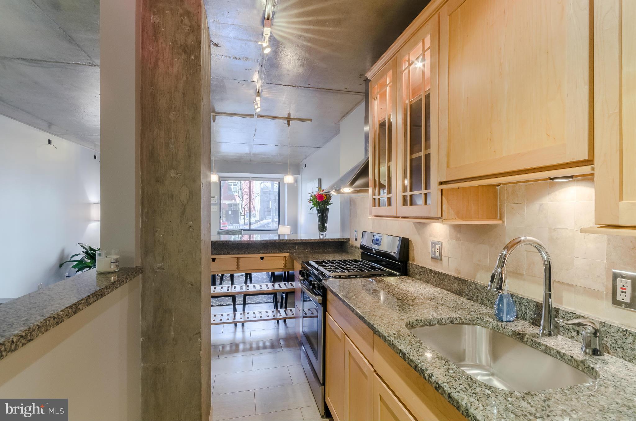 1245 13th Street Northwest, Unit 101 Washington, DC 20005 - Photo 9 of 25 a kitchen with stainless steel appliances granite countertop a sink stove and cabinets