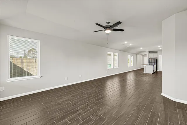 a view of empty room with wooden floor and window