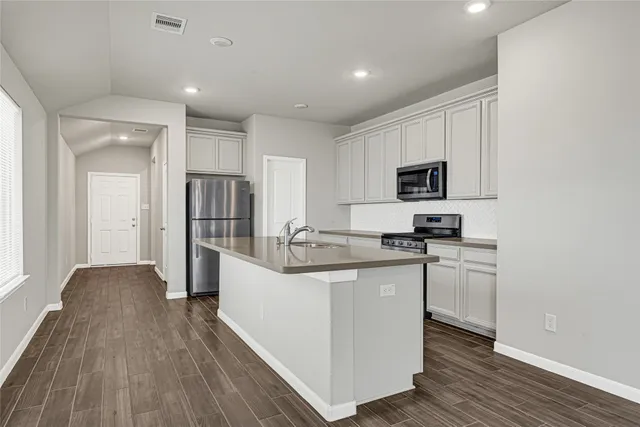 a kitchen with white cabinets and stainless steel appliances