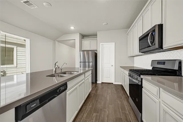 a kitchen with stainless steel appliances granite countertop a sink stove and refrigerator