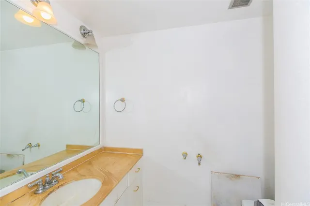 a living room with painting on the wall and a potted plant