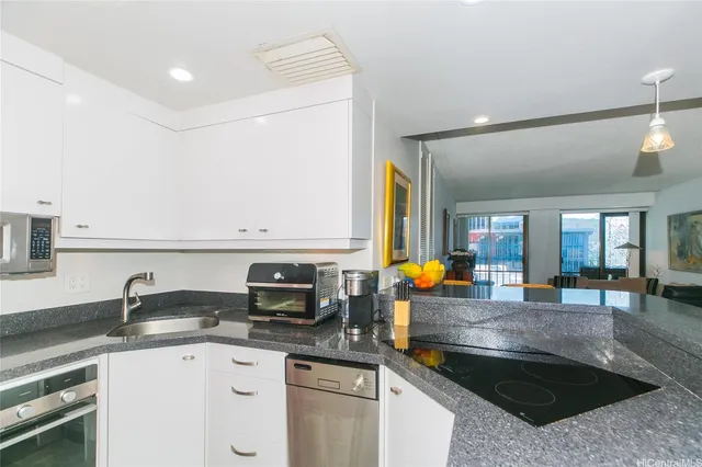 a kitchen with stainless steel appliances granite countertop a sink stove and cabinets