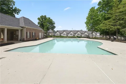 a view of a house with pool lawn chairs and a yard