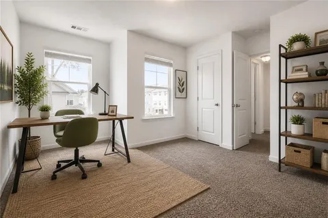 a view of a workspace with furniture and a window