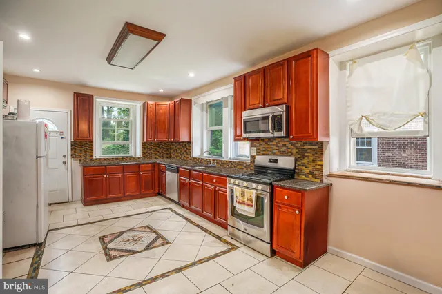 a kitchen with stainless steel appliances a stove a refrigerator sink microwave and cabinets