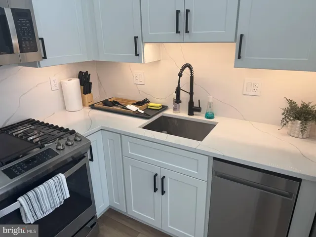 a kitchen with a sink stainless steel appliances and cabinets