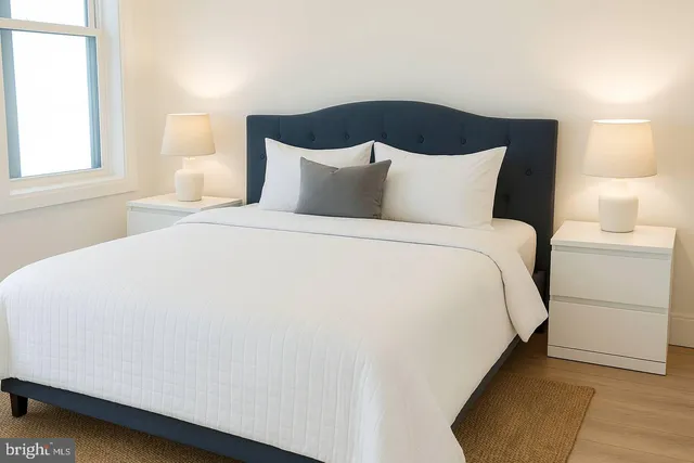 a large bed sitting in a bedroom next to a window