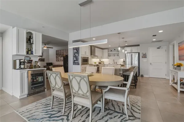 a kitchen with a dining table chairs and white cabinets