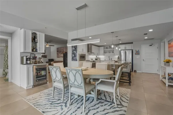 a kitchen with stainless steel appliances granite countertop a sink a stove a refrigerator cabinets and chairs