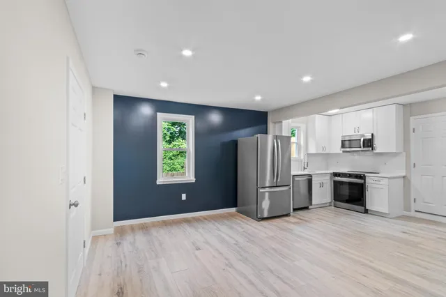 a open kitchen with a refrigerator and a stove top oven