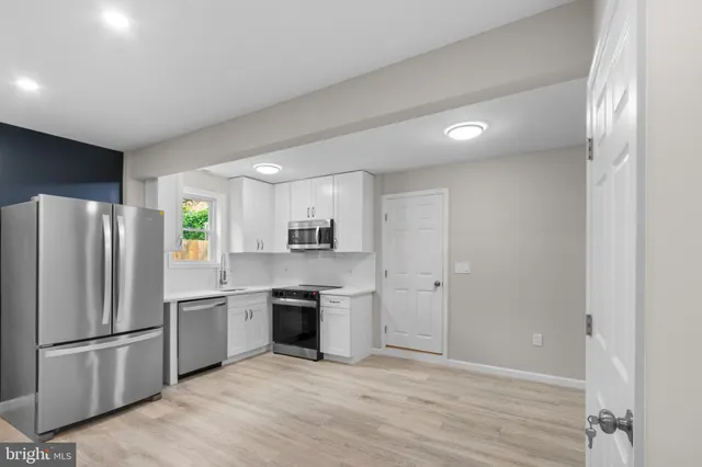 a kitchen with stainless steel appliances a refrigerator sink and stove