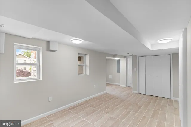 an empty room with windows and closet