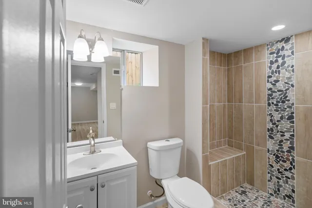 a bathroom with a toilet a sink and shower