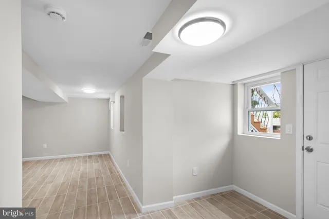 a view of a room with wooden floor and window