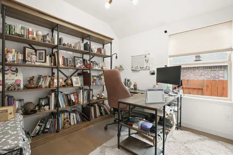 a view of a workspace with furniture and a book shelf