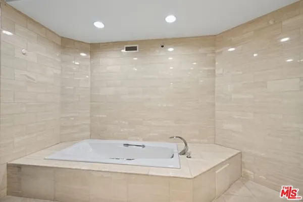 a bathroom with a tub a sink and a shower