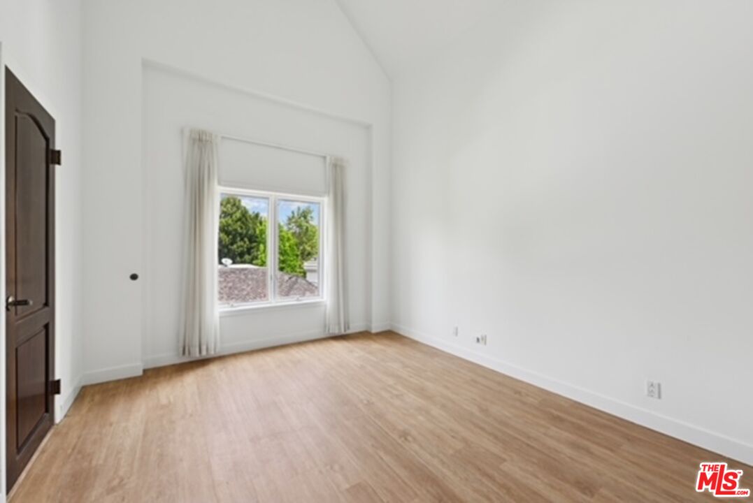 10351 Wilshire Boulevard, Unit PH1 Los Angeles, CA 90024 - Photo 20 of 23 a view of an empty room with wooden floor and a window