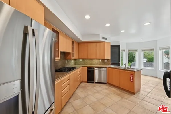 a kitchen with stainless steel appliances granite countertop a refrigerator and a stove top oven